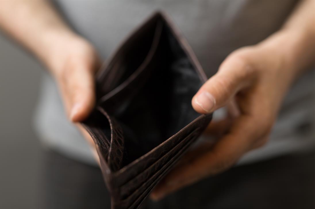 The picture shows a wallet that is held up by two hands and is empty. Symbolically, it is meant to represent poverty.